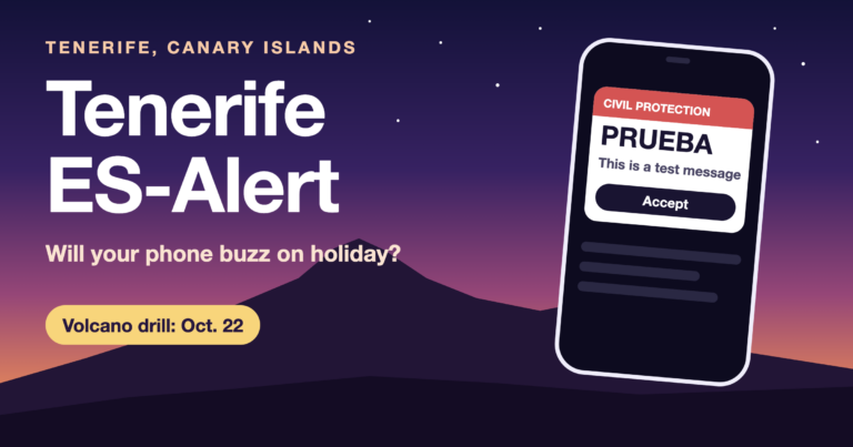 Tenerife ES-Alert cover: phone showing a PRUEBA test alert in front of Mount Teide at dusk